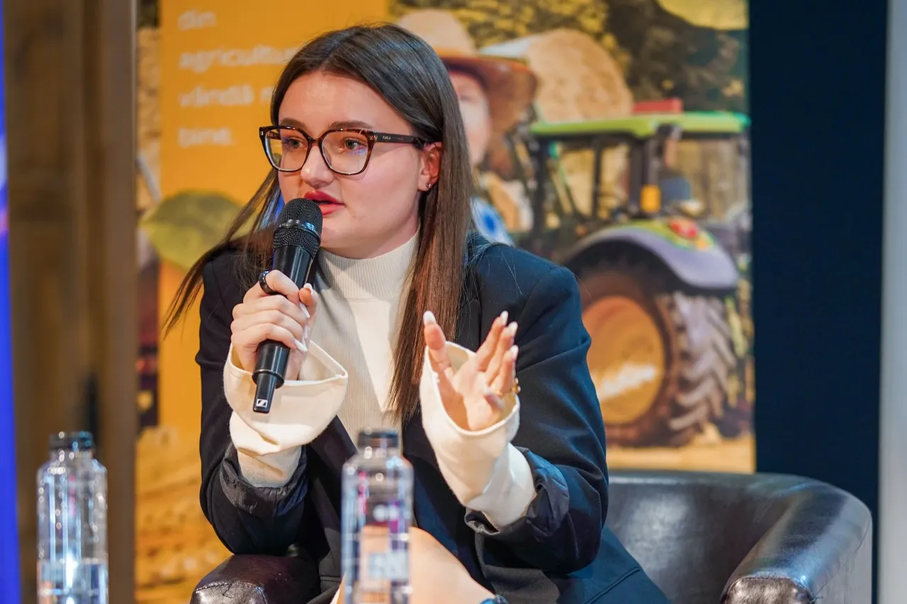Sabina vorbind la microfon în cadrul unei conferințe