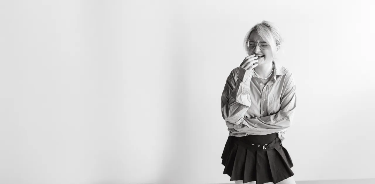 Sabina Milițoiu râzând, fotografie alb-negru pe fundal alb